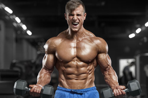 Man with muscles lifting dumbbells