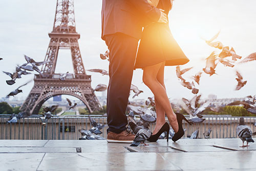 Man and Woman holding each other in front of Tour D'Eiffel in Paris, France