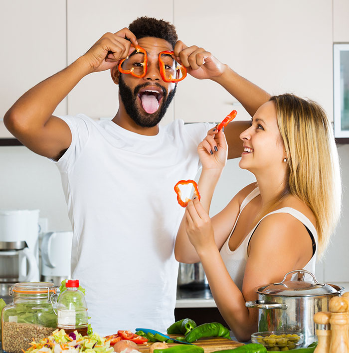 Couple cooking together being goofy