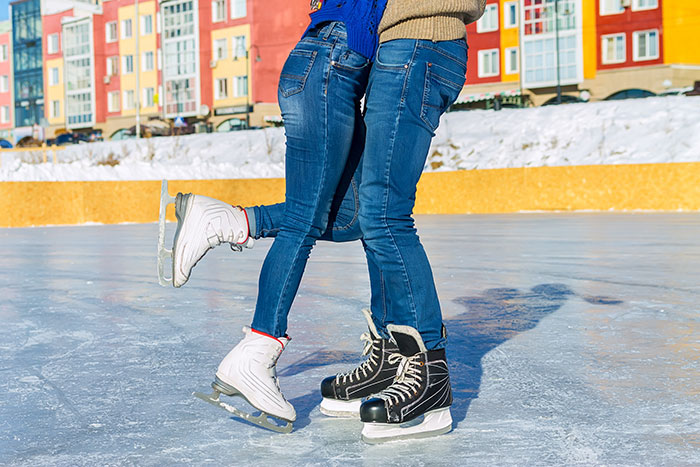 Couple ice skating; girl falling into man's arms